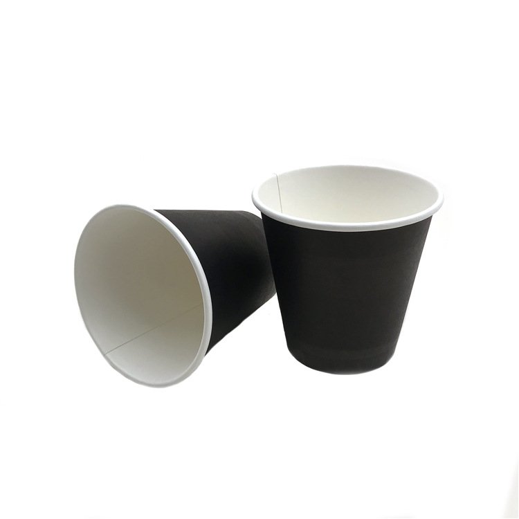 Two black paper cups, one upright and one turned on its side to show the white lined interior
