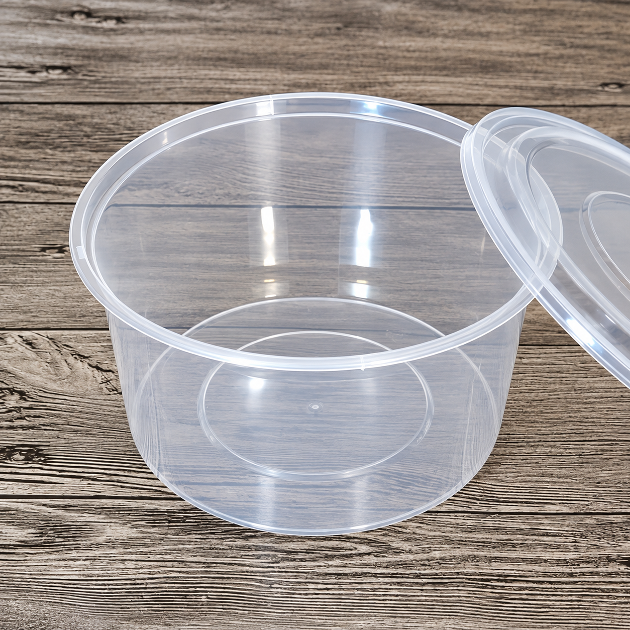 Open clear plastic round food container with matching lids