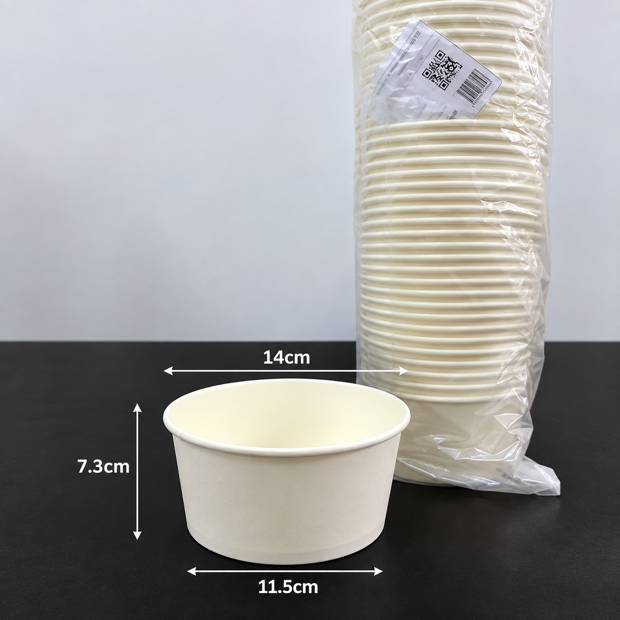 Paper bowl with marked dimensions beside packed stack
