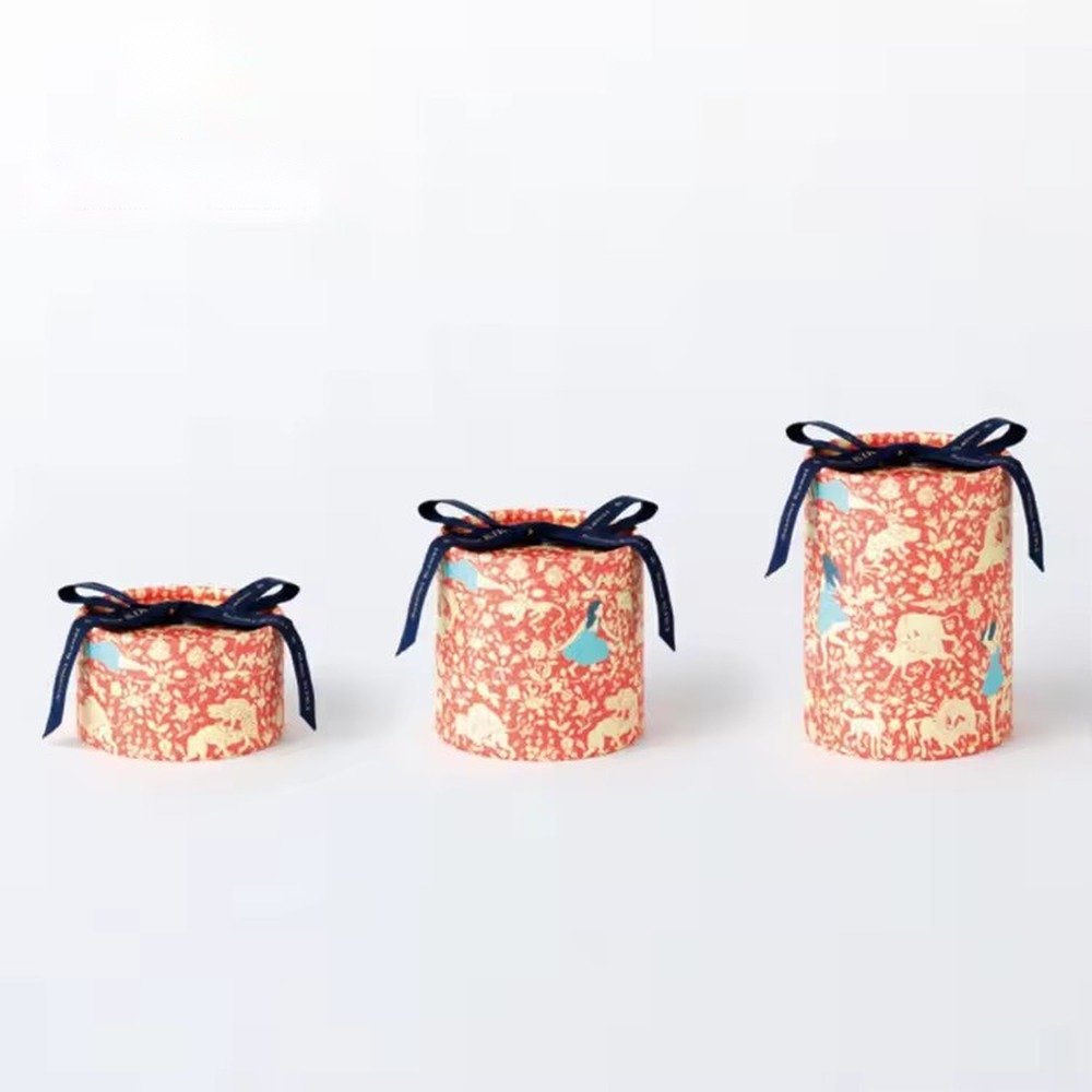 Round paper tube gift boxes in red floral print with navy ribbon bows