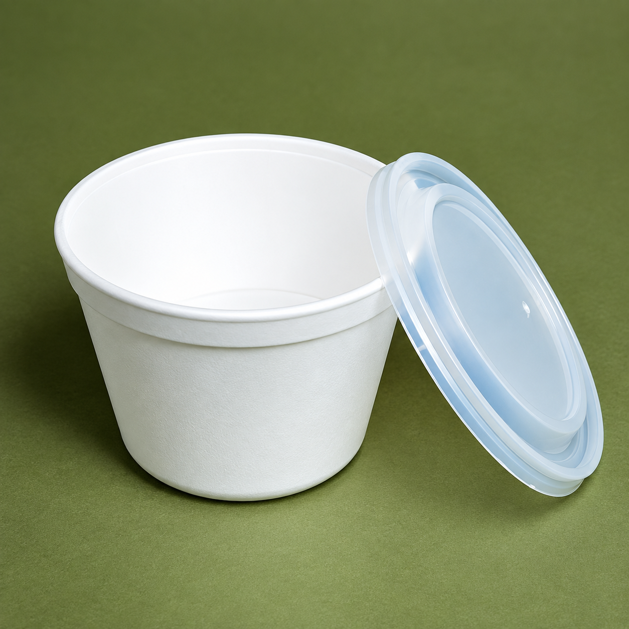 White paper bowl with separate clear plastic lid on green background